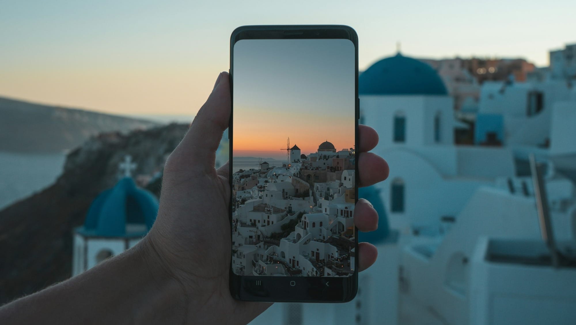 person holding black smartphone taking photo of city during daytime