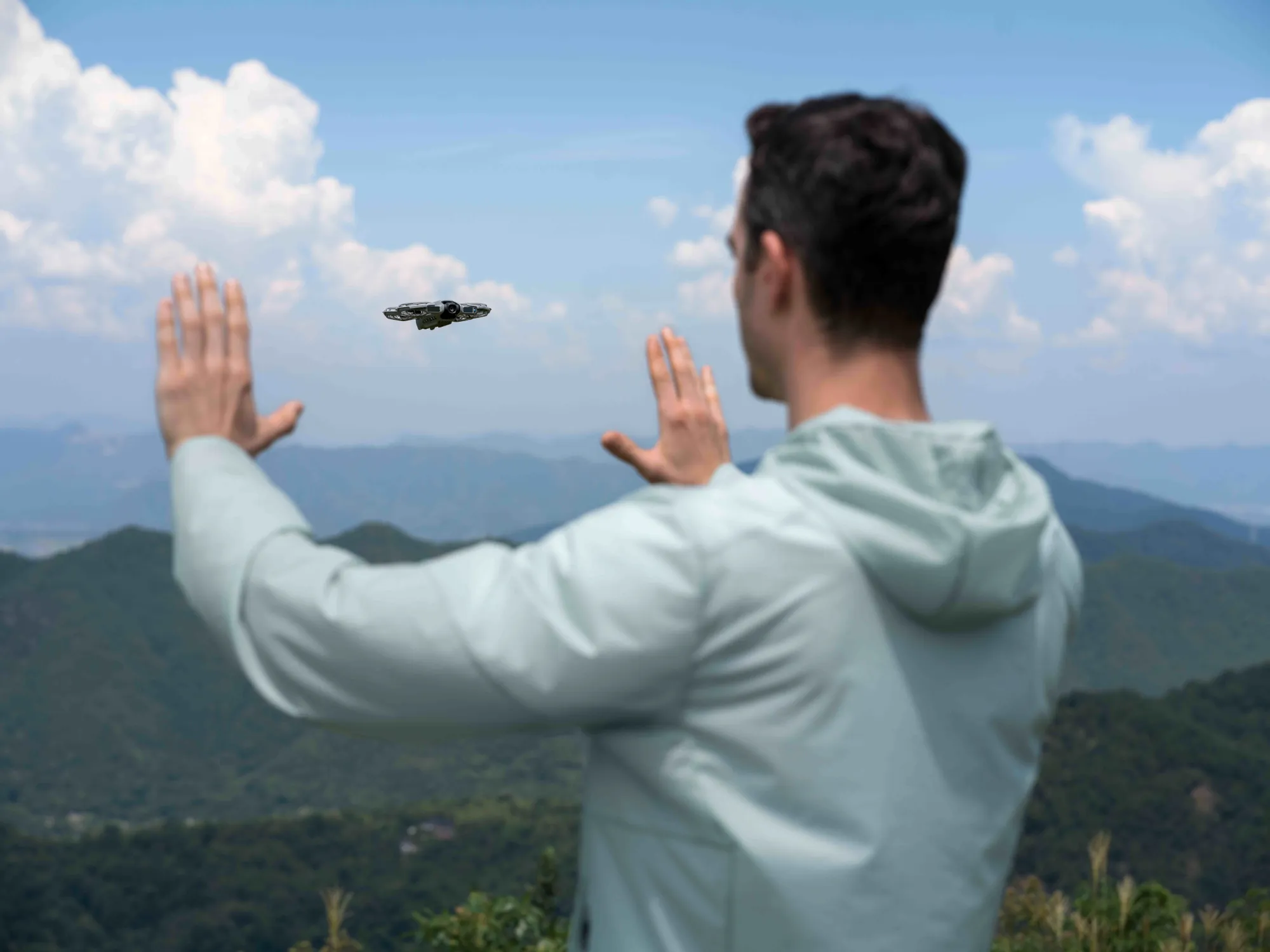 Con le mani entrambe rivolte verso il drone, allontanadole si fa volare il drone lontano, viceversa avvicinandole si fa avvicinare il drone verso di noi.